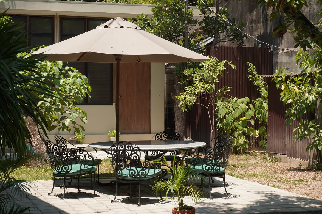 Garden courtyard with wrought iron table and lush trees